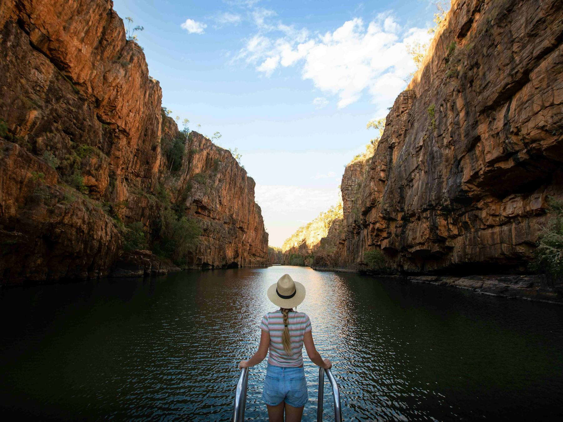 Woman holding onto rails while touring on a cruise in Katherine Gorge