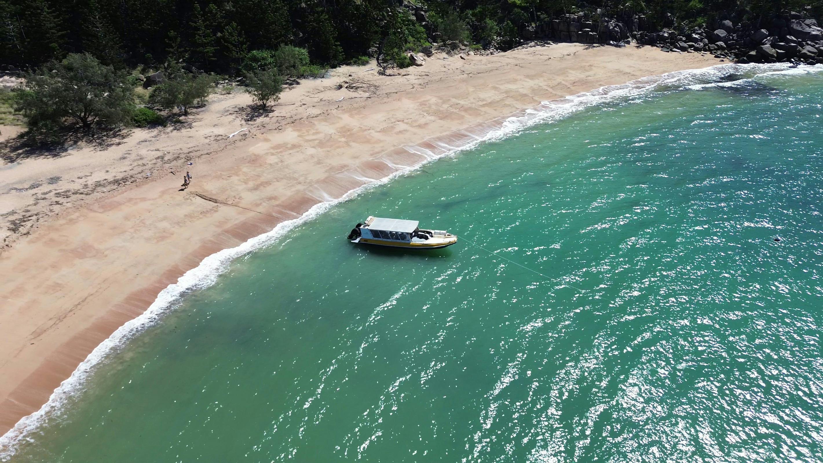 Boat front and back anchored by the beach