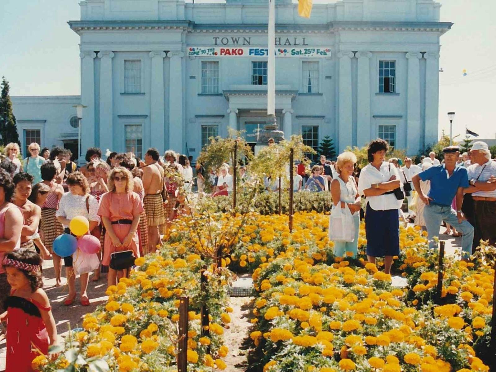 crowd photo outside Geelong West Town hall with yellow flowers.