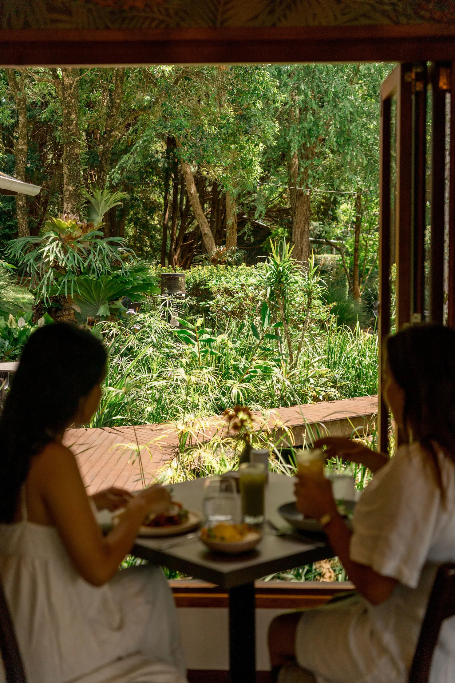 Two women dining at The Tamarind with rainforest views