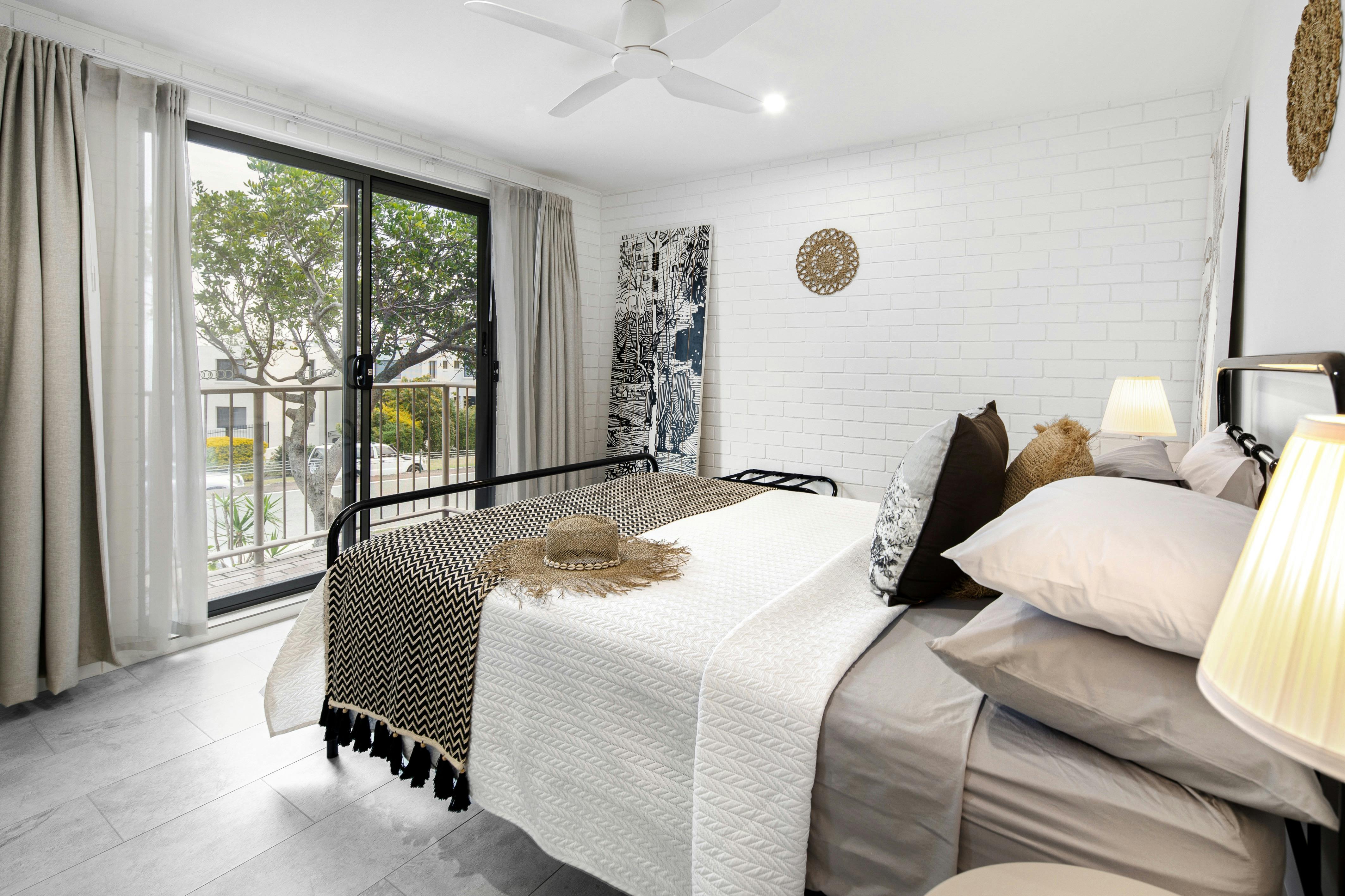 The main bedroom has aircon, fan, views, queen bed, and crisp clean bedding