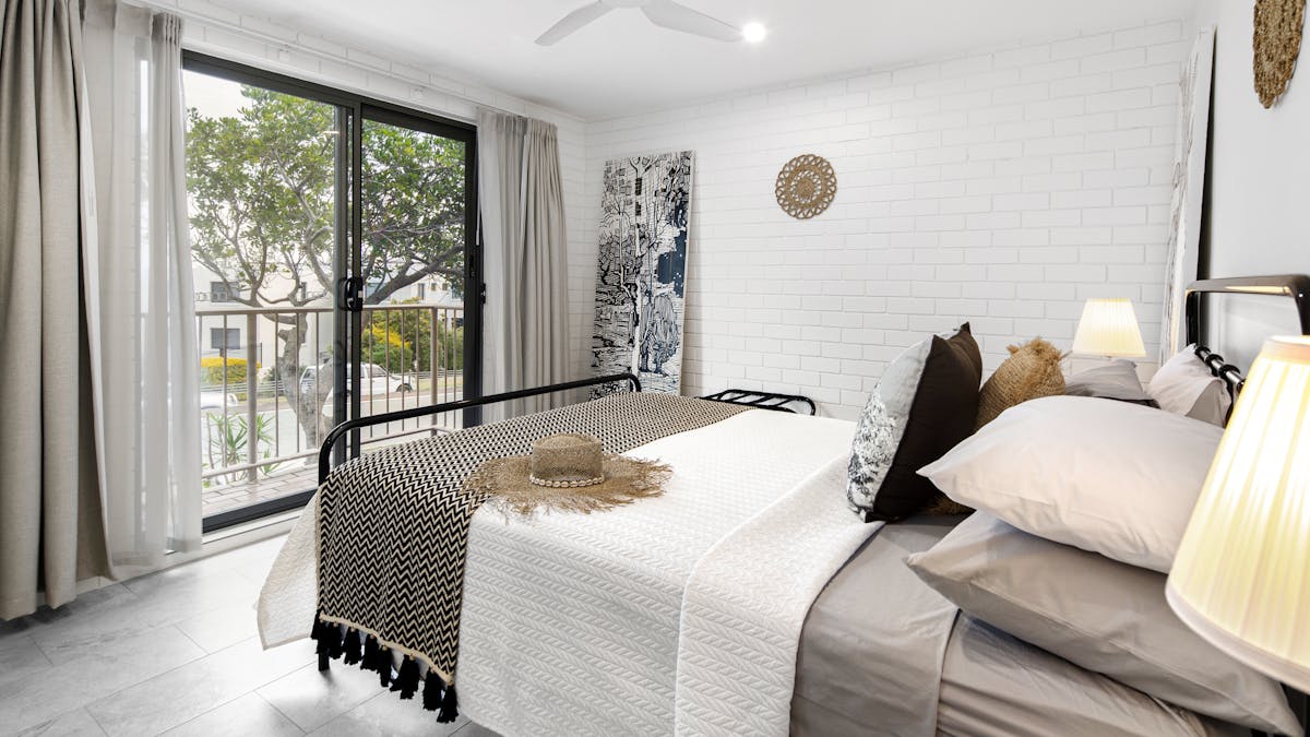 interior photo of queen bed, art, roof fan and luxury bed