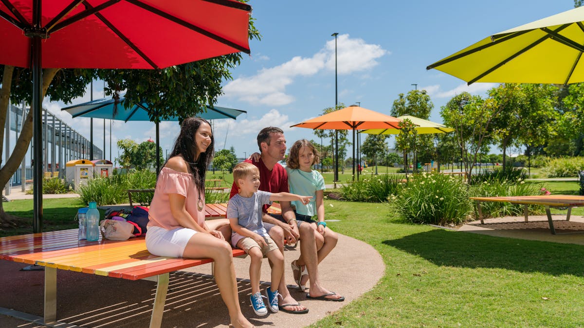 Family enjoying the grassy parklands of the East Shores Precinct Family enjoying the grassy parklands of the East Shores Precinct