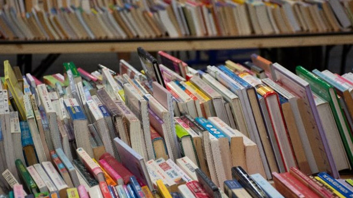 Close up of books of different sizes lined up together on the table Close up of books of different sizes lined up together on the table