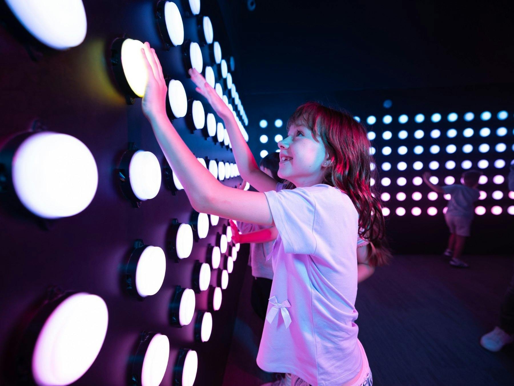 Kids enjoying an exciting interactive light-up wall challenge at Power Play Sydney.