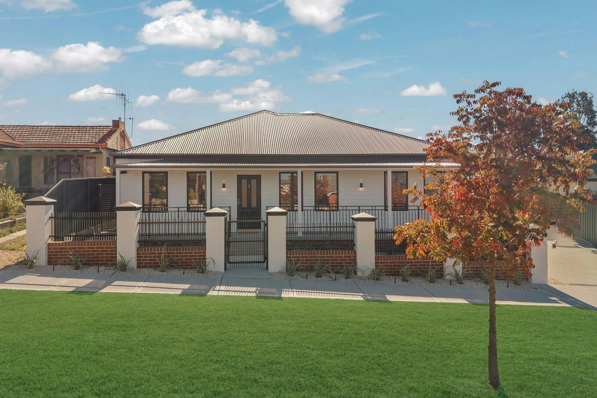Modern front apartment with rendered brick, large front fence and side driveway.