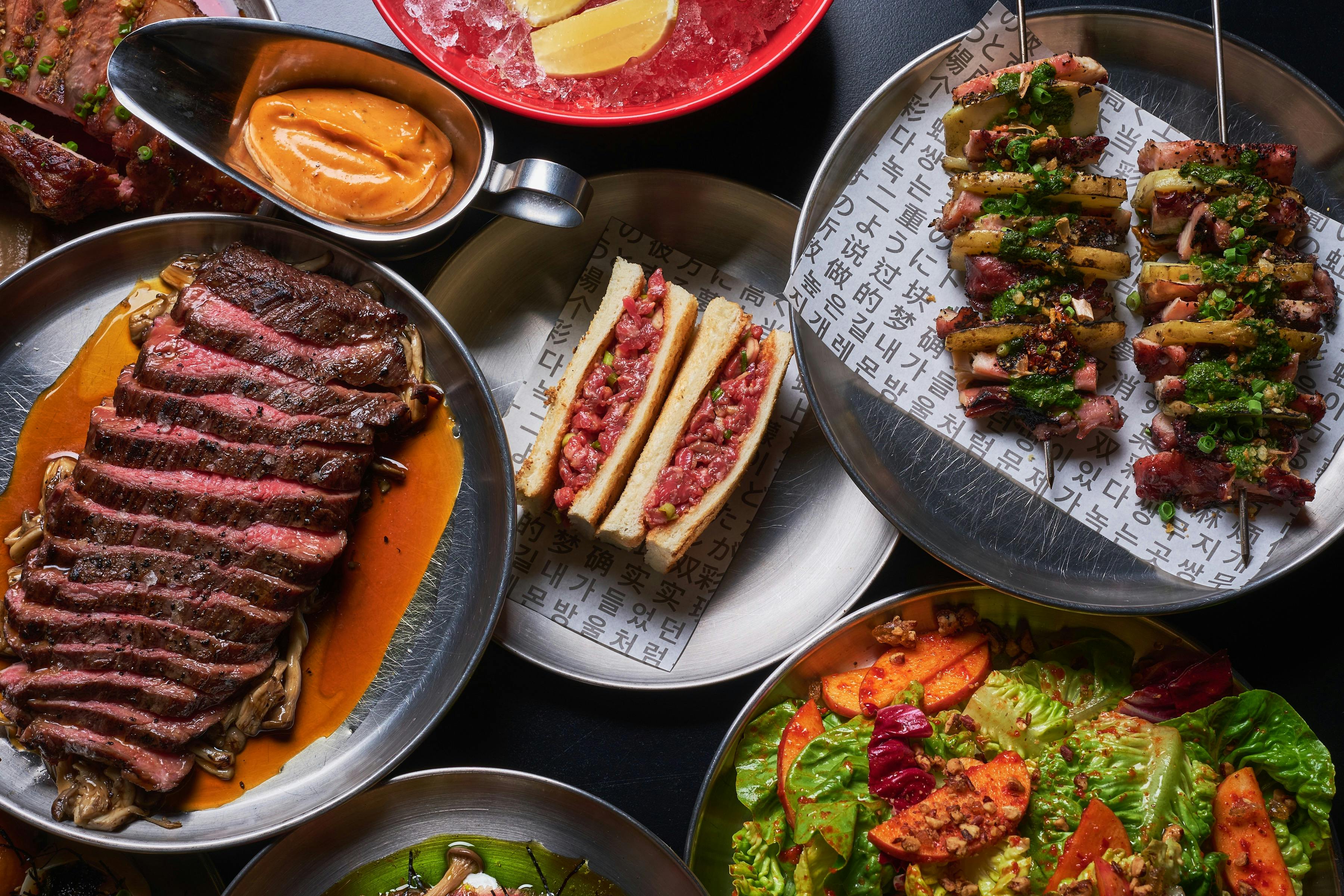 A flat lay photo of steak, salads and other dishes included in some of our set menus.