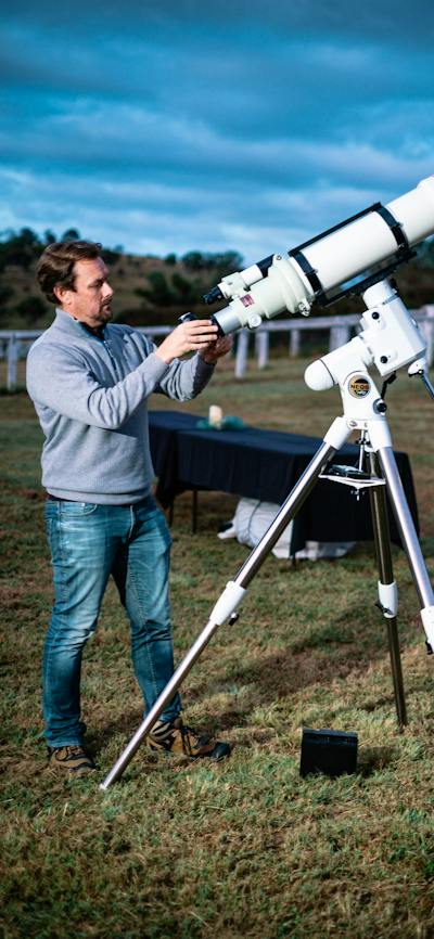 Man adjusts telescope at Lanyon Homestead