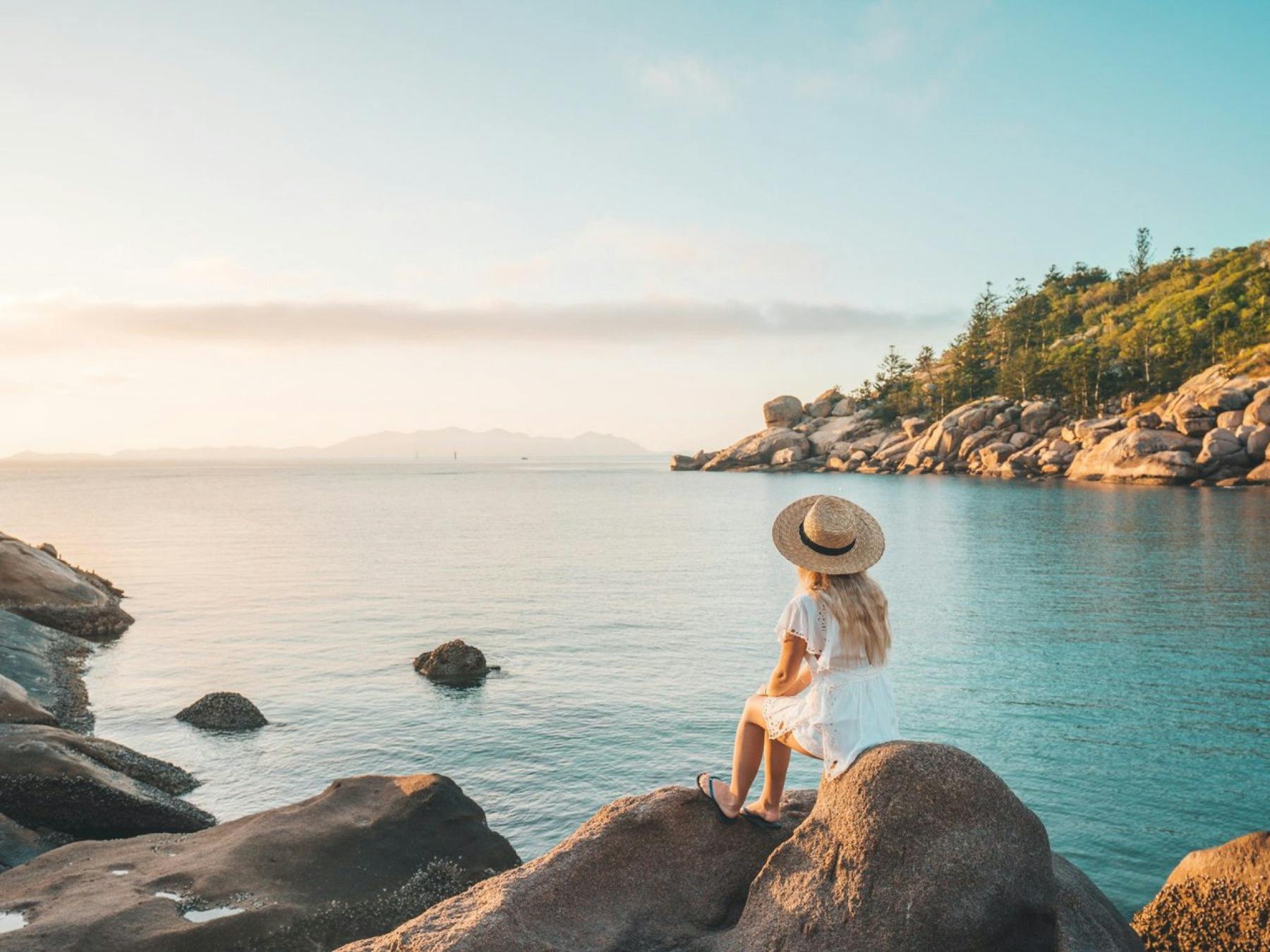 Women sitting on rock overlooking water