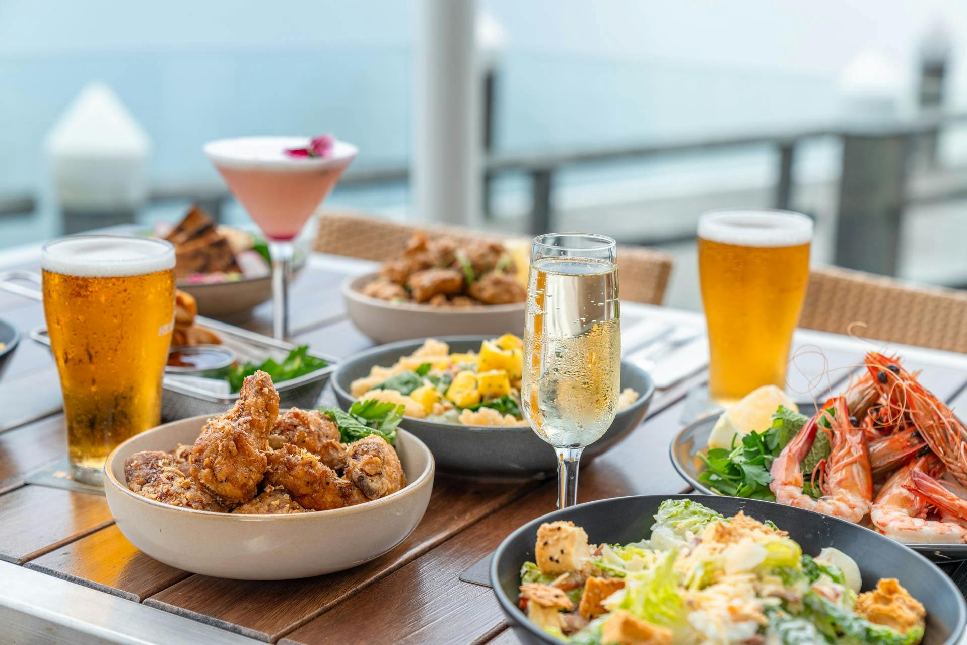 Table of various plates of food, wine, cocktail and beer