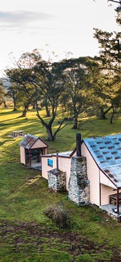 A bird's eye view of a couple walking to Daffodil Cottage, Kosciuszko National Park. Photo: Rob