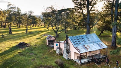 A bird's eye view of a couple walking to Daffodil Cottage, Kosciuszko National Park. Photo: Rob
