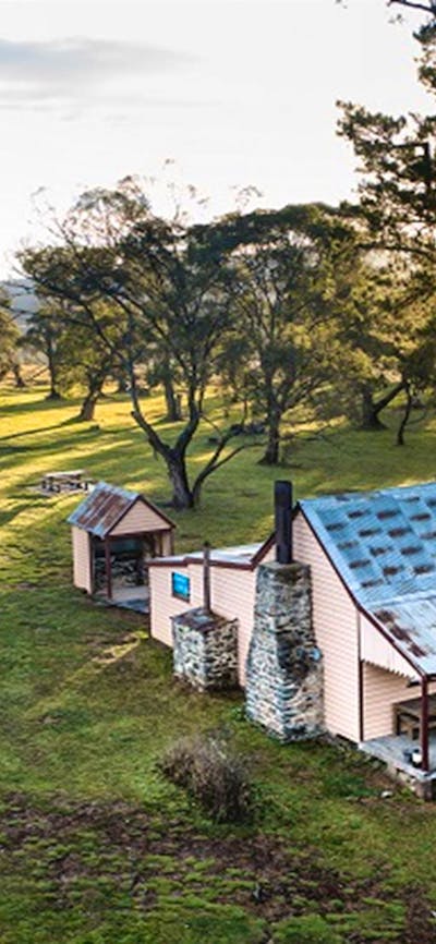 A bird's eye view of a couple walking to Daffodil Cottage, Kosciuszko National Park. Photo: Rob