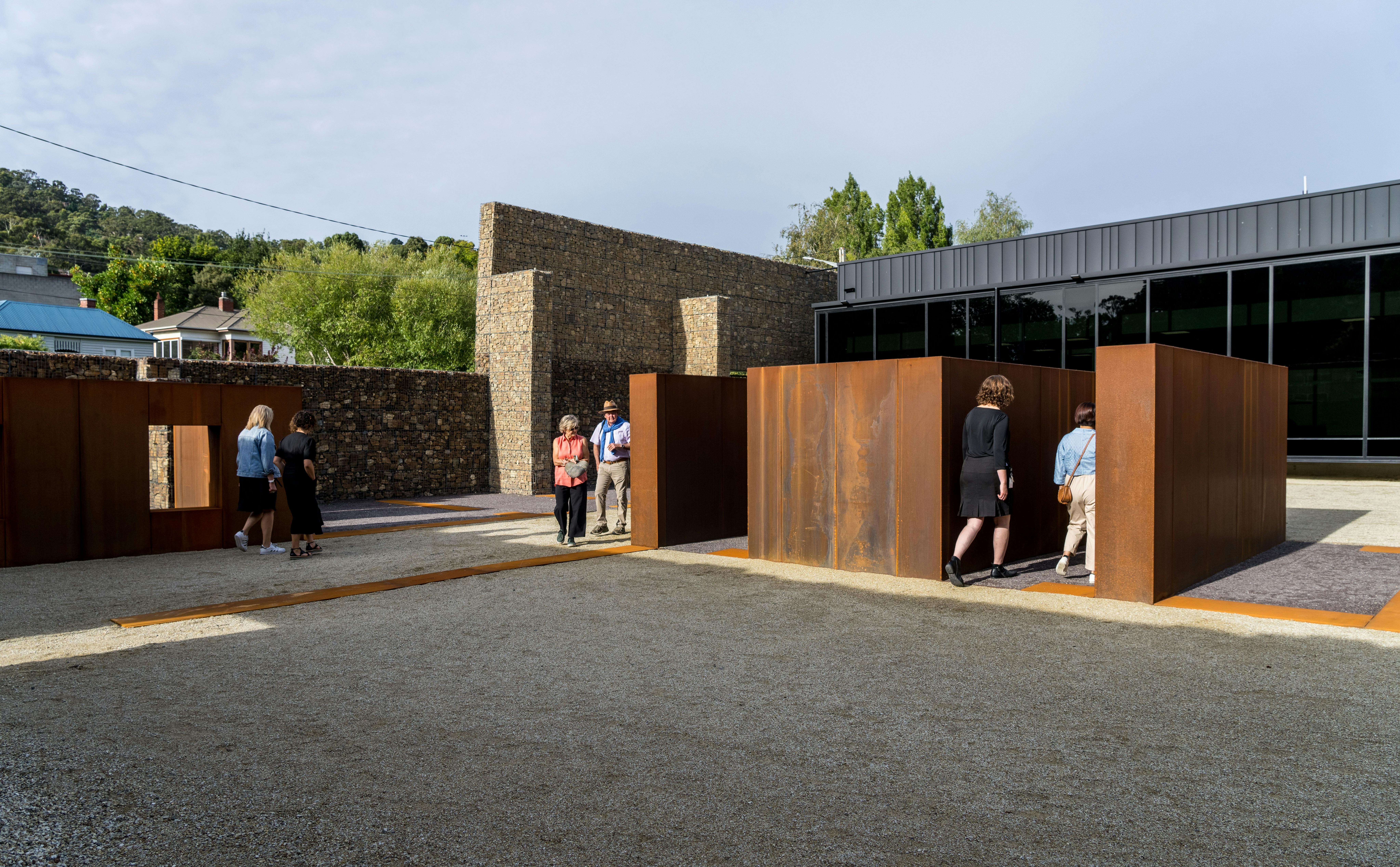 3 couples walks into different directions around some metal cells that replicate what the old cells.