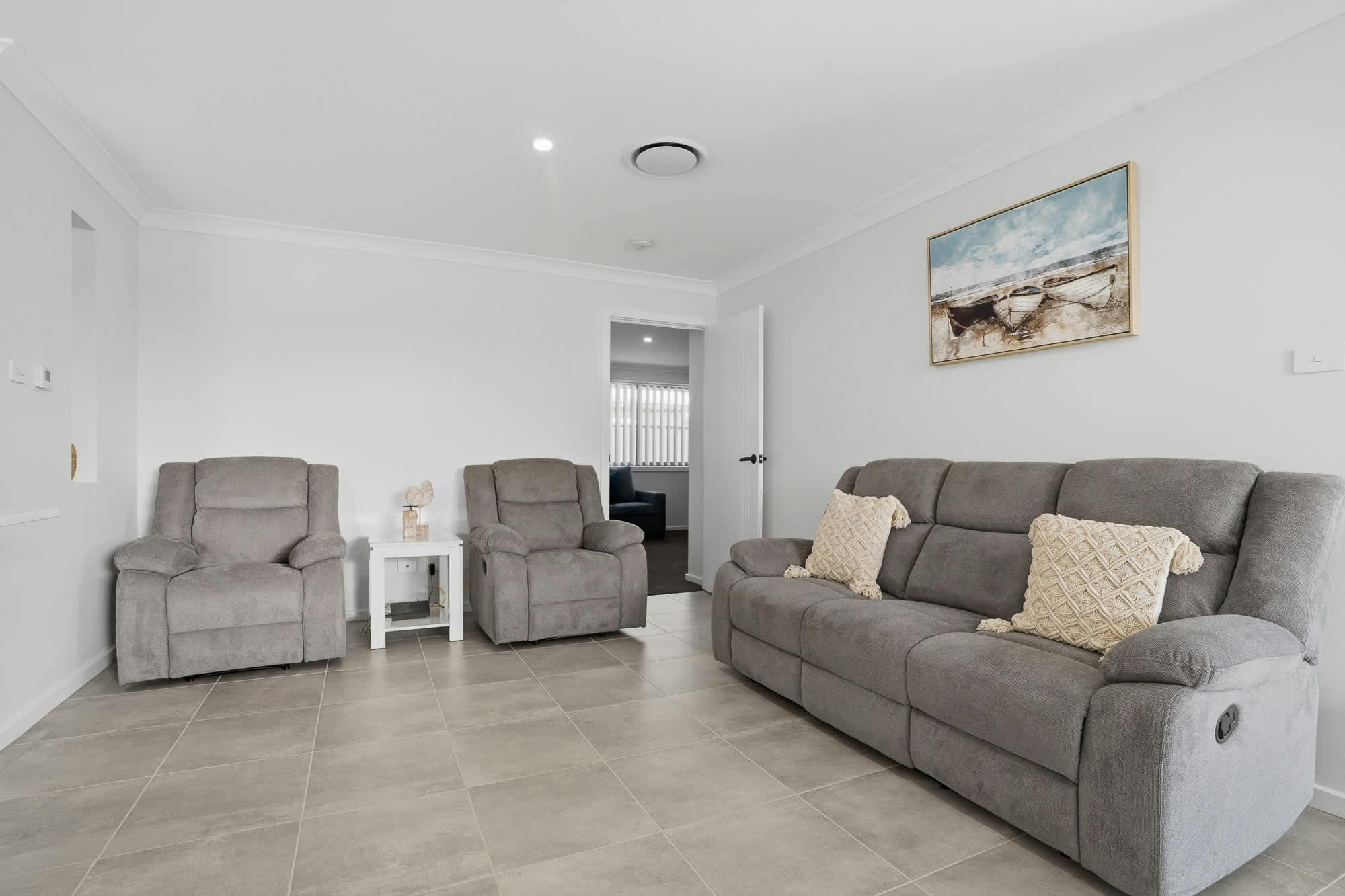 Lounge room with 3 seater couch and 2 arm chairs