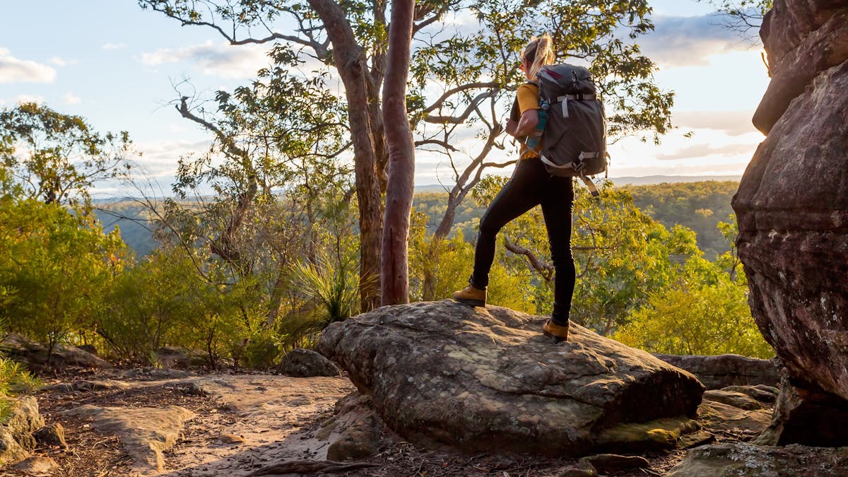 Hiker standing on a rock looking out at a view