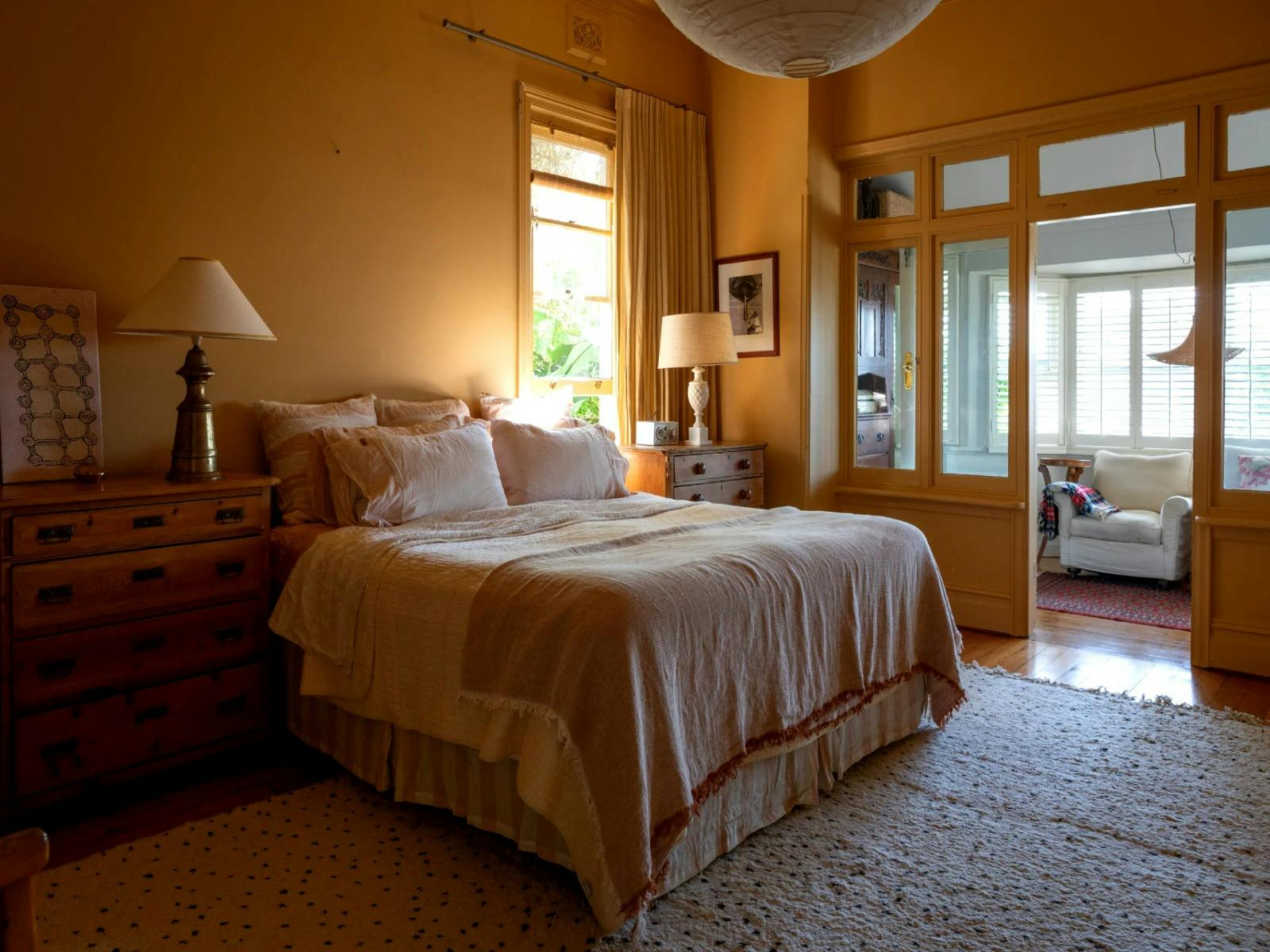 Oversized master bedroom flows into a sunroom that offers a sitting area complete with garden views