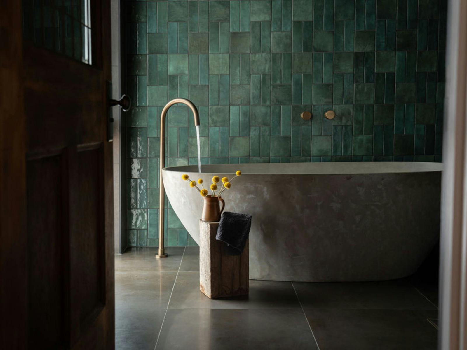 Luxurious moody bathroom complete with soaking tub and rain shower