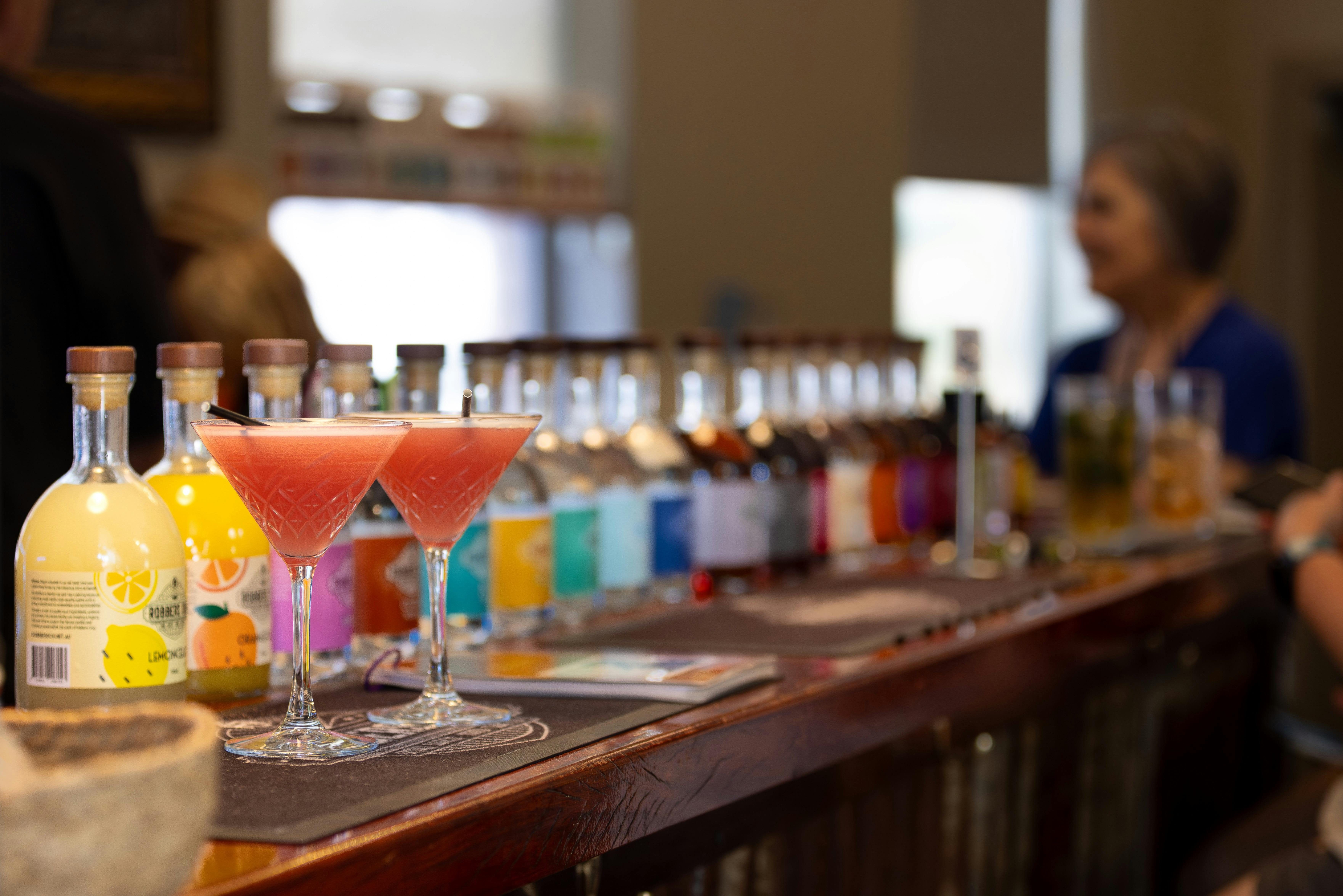 Strawberry Daiquiris cocktails on the bar, set against Robbers Dog’s wide range of spirits to taste.