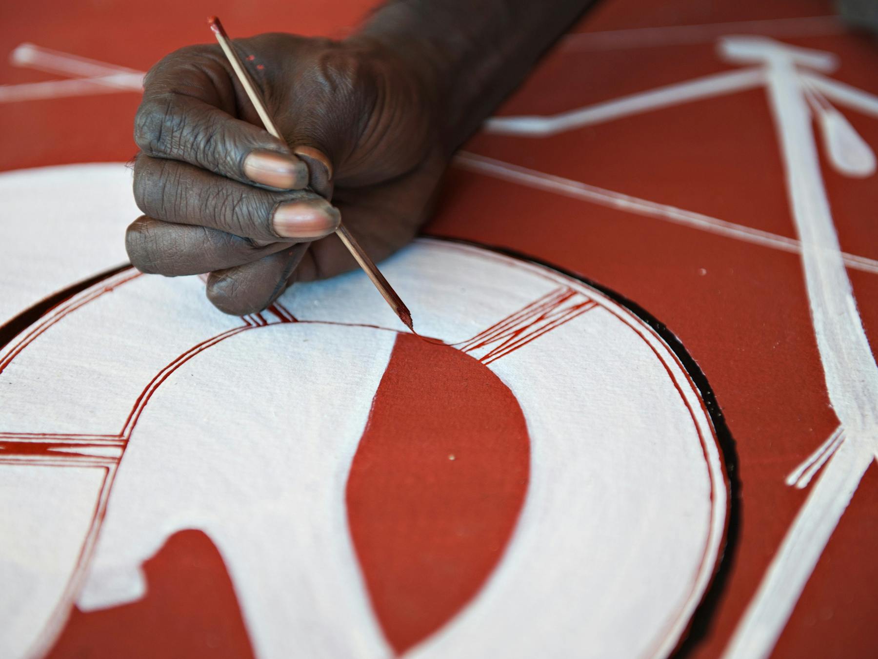 Injalak artist using traditional (rarrk) methods on a canvas