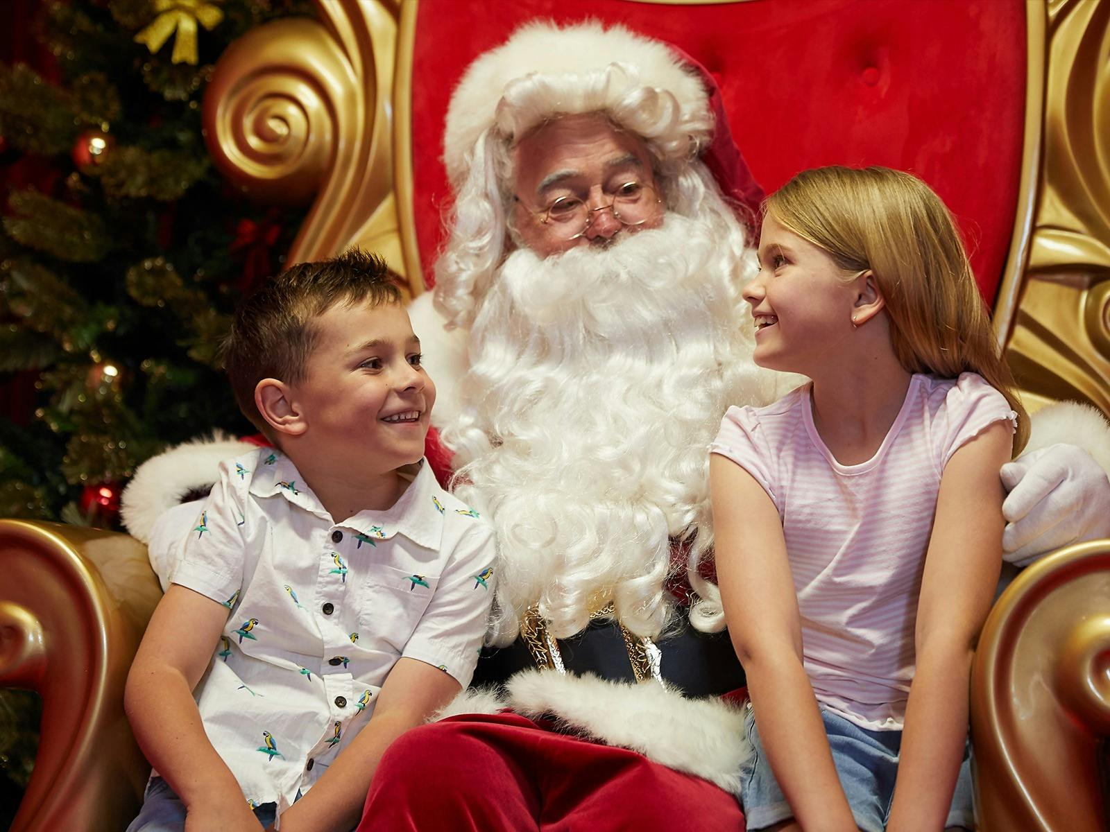 Santa sits with two children
