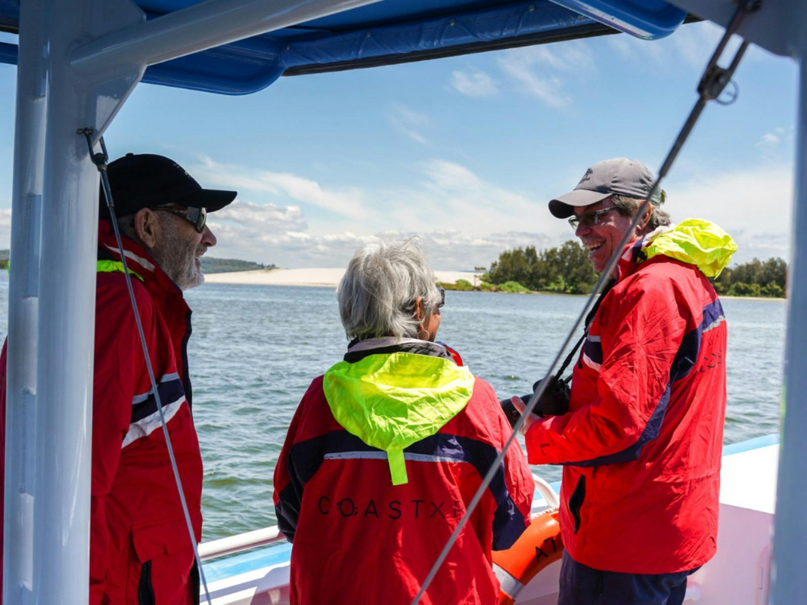 Bootsführer spricht zu Gästen mit Schwimmwesten.