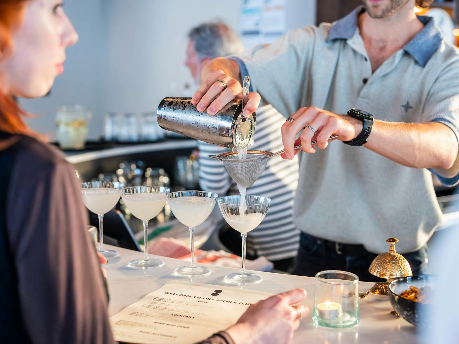 Bartender pouring cocktails at Dill Pickle Club