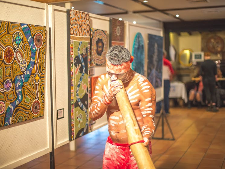 Performer plaing the yidaki as he leads guests throuhg the art display on wupa opening night.