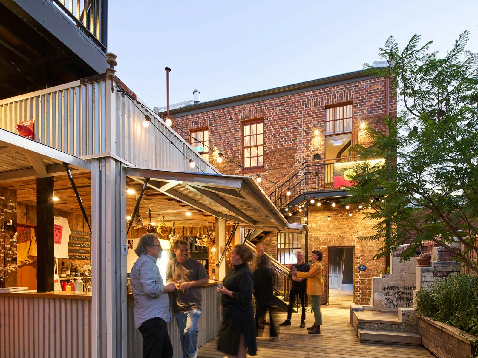 At dusk, the lights in La Mama's forecourt are on and people gather before a show and share a drink.