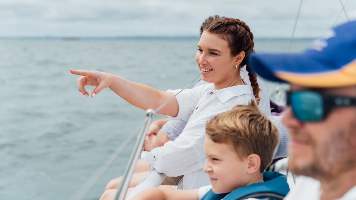 Southern Cross Yachting - people enjoying the water from the side of a sailing yacht