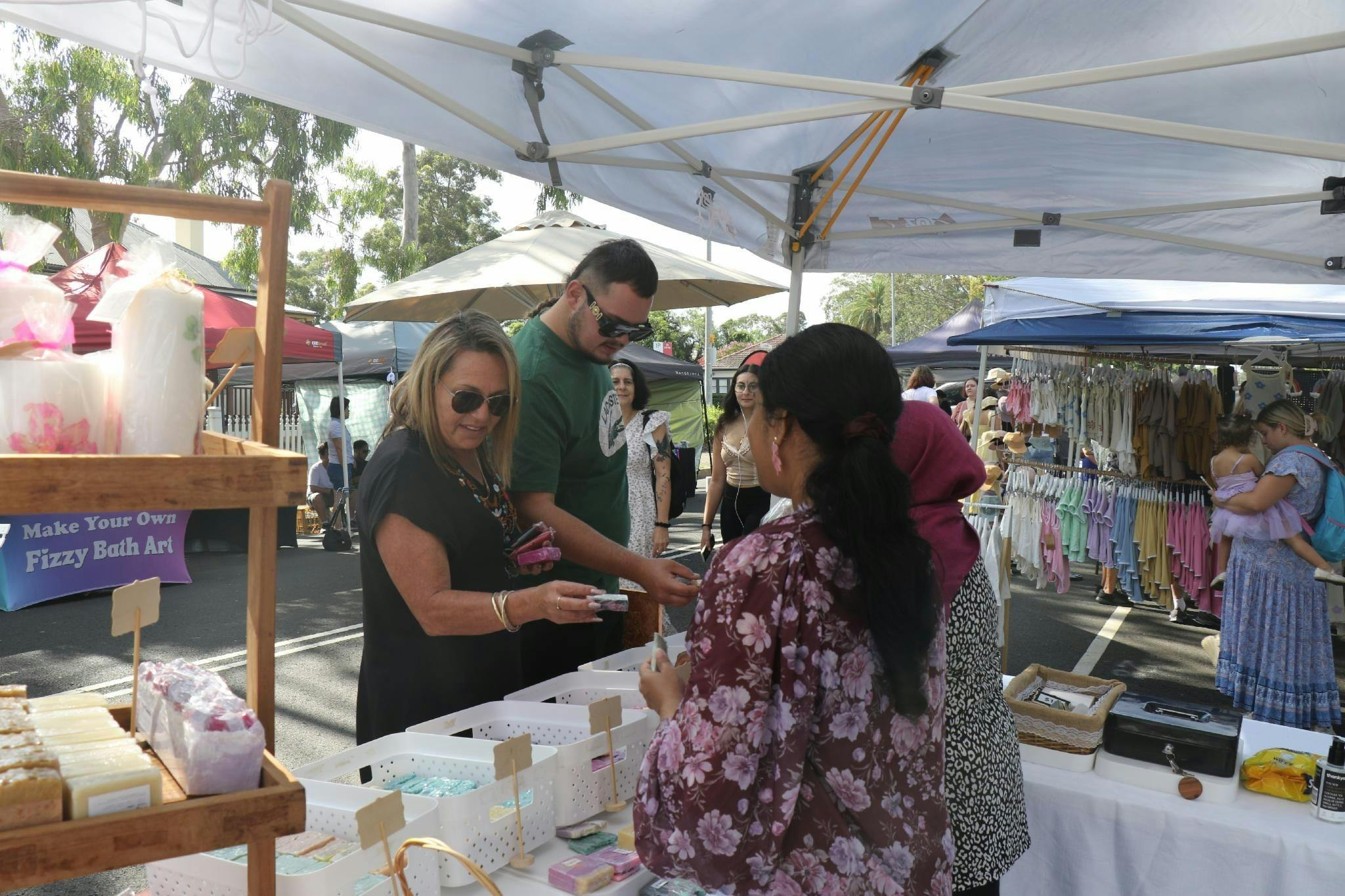 Customers browsing the wares of a market stall.