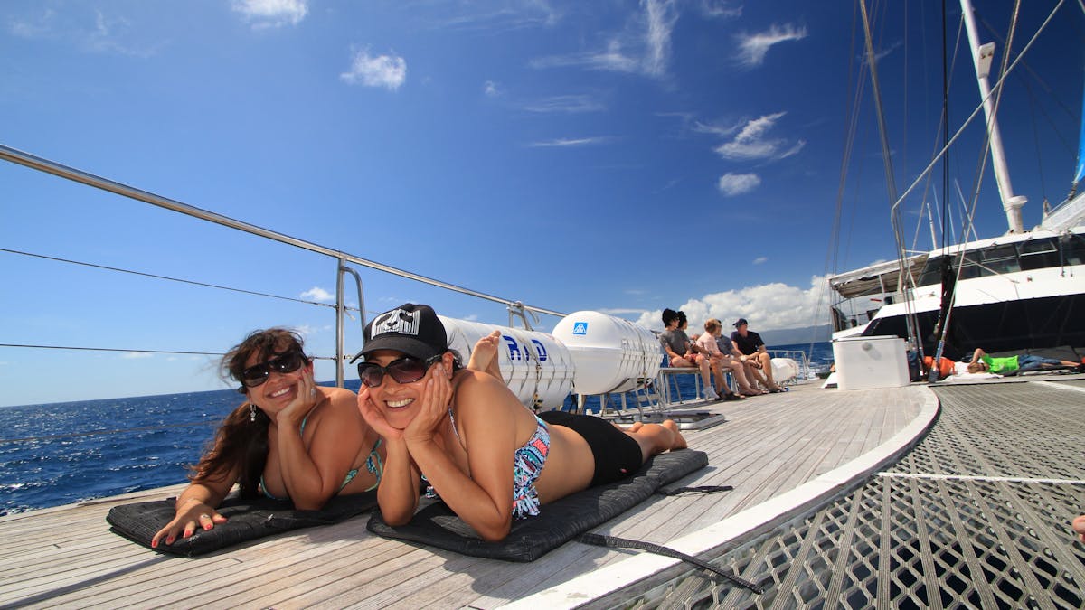 girls sun bathing on Ocean Spirit foredeck