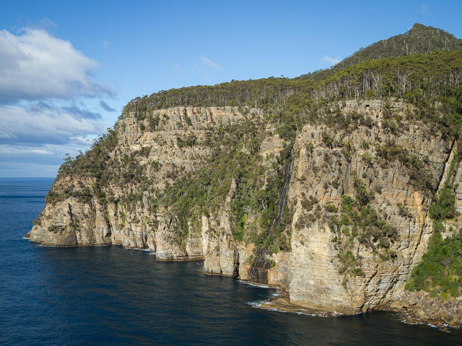 Coastal waterfall where the mountain meets the sea at Tasman Peninsula