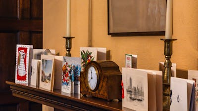 Calthorpes House mantlepiece with small clock and Christmas cards