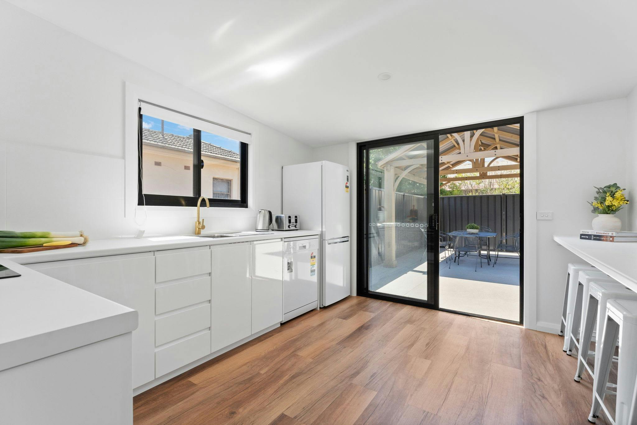 Open kitchen with bench seating and sliding door to outside