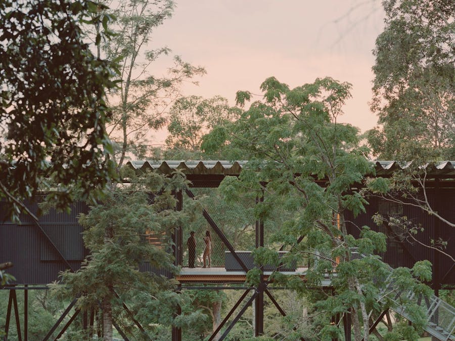 Visitors chatting on a breezeway on The Bridge, a n eco-accomodation building that spans a gully