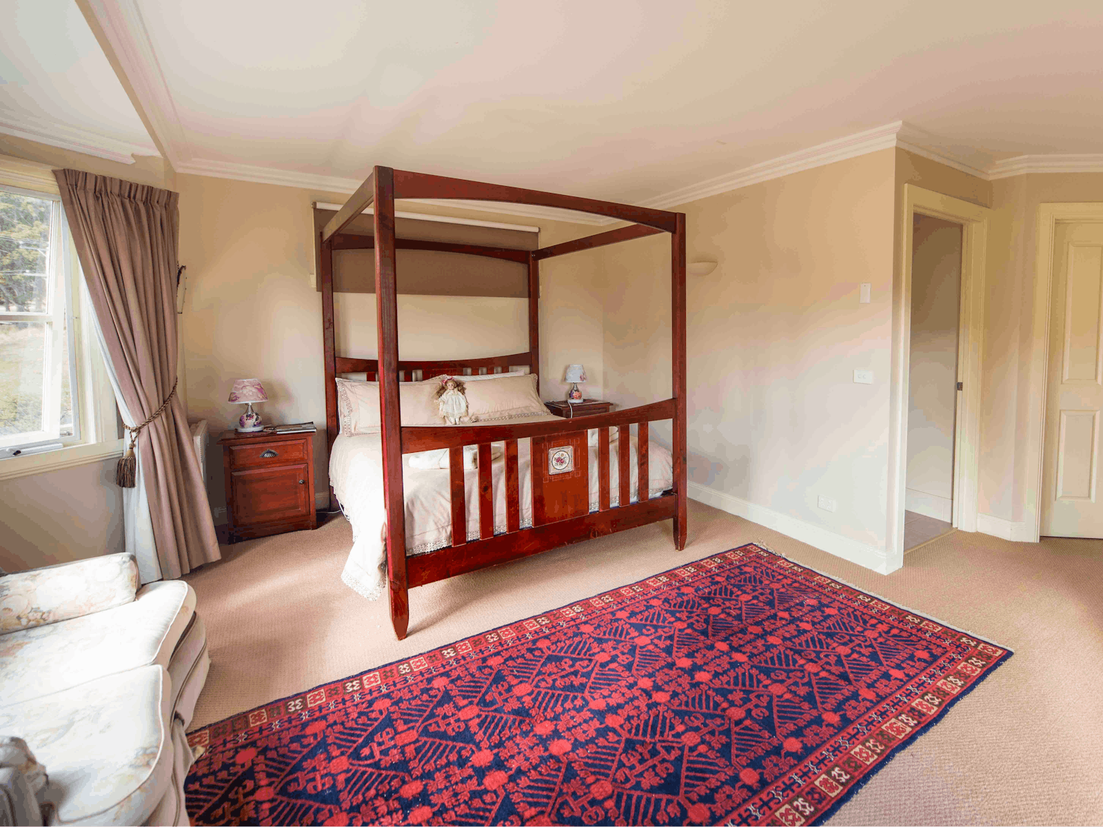 View of four poster bed, sitting area and ensuite