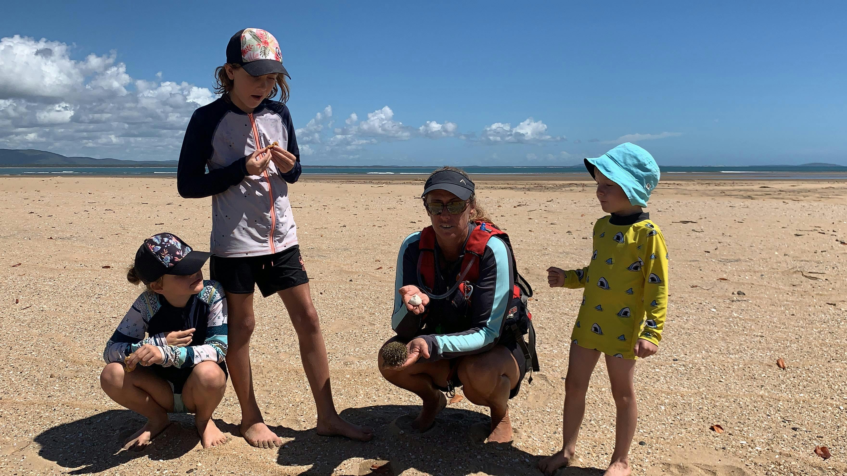 Kayak guide and kids exploring nature1770 Liquid Adventures Tour guide showing the kids a sea urchin