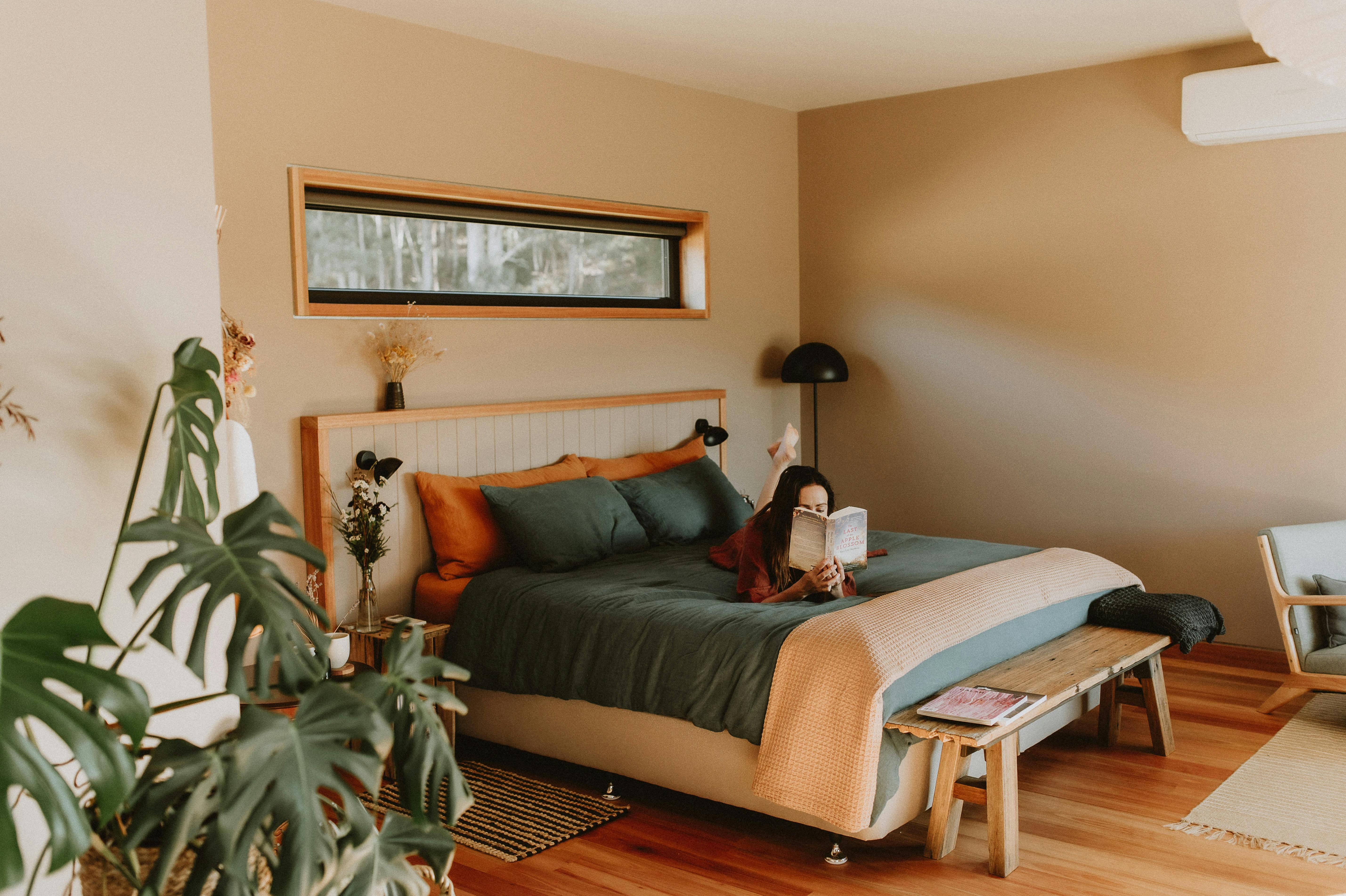 A lady reading a book on a bed