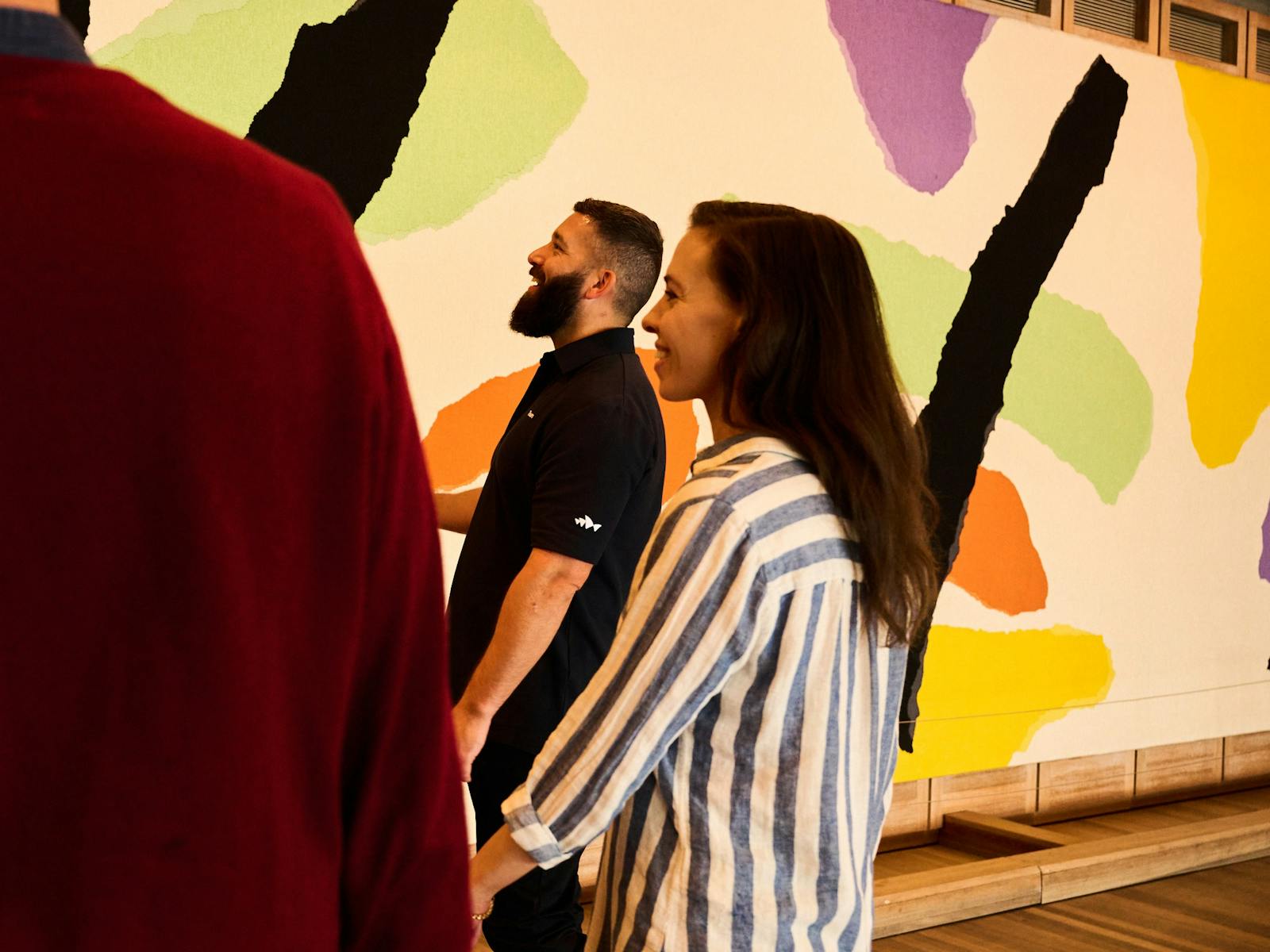 Tour guide and woman standing in front of the Utzon Tapestry