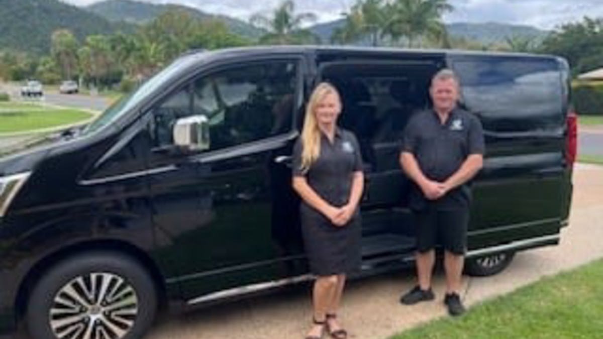 2 people infront of a black van