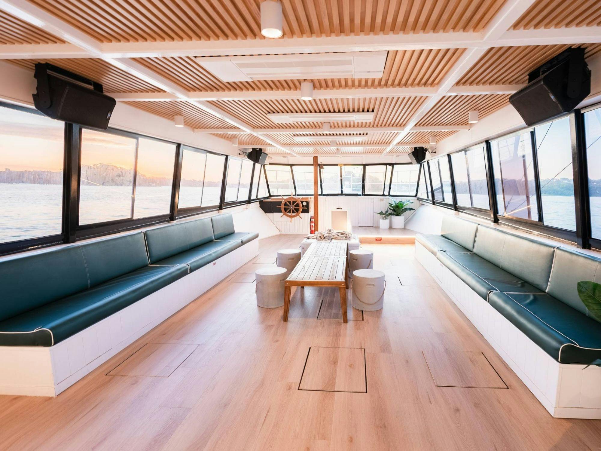 Indoor lounge area of Zahara with bench seating and harbour views through the windows