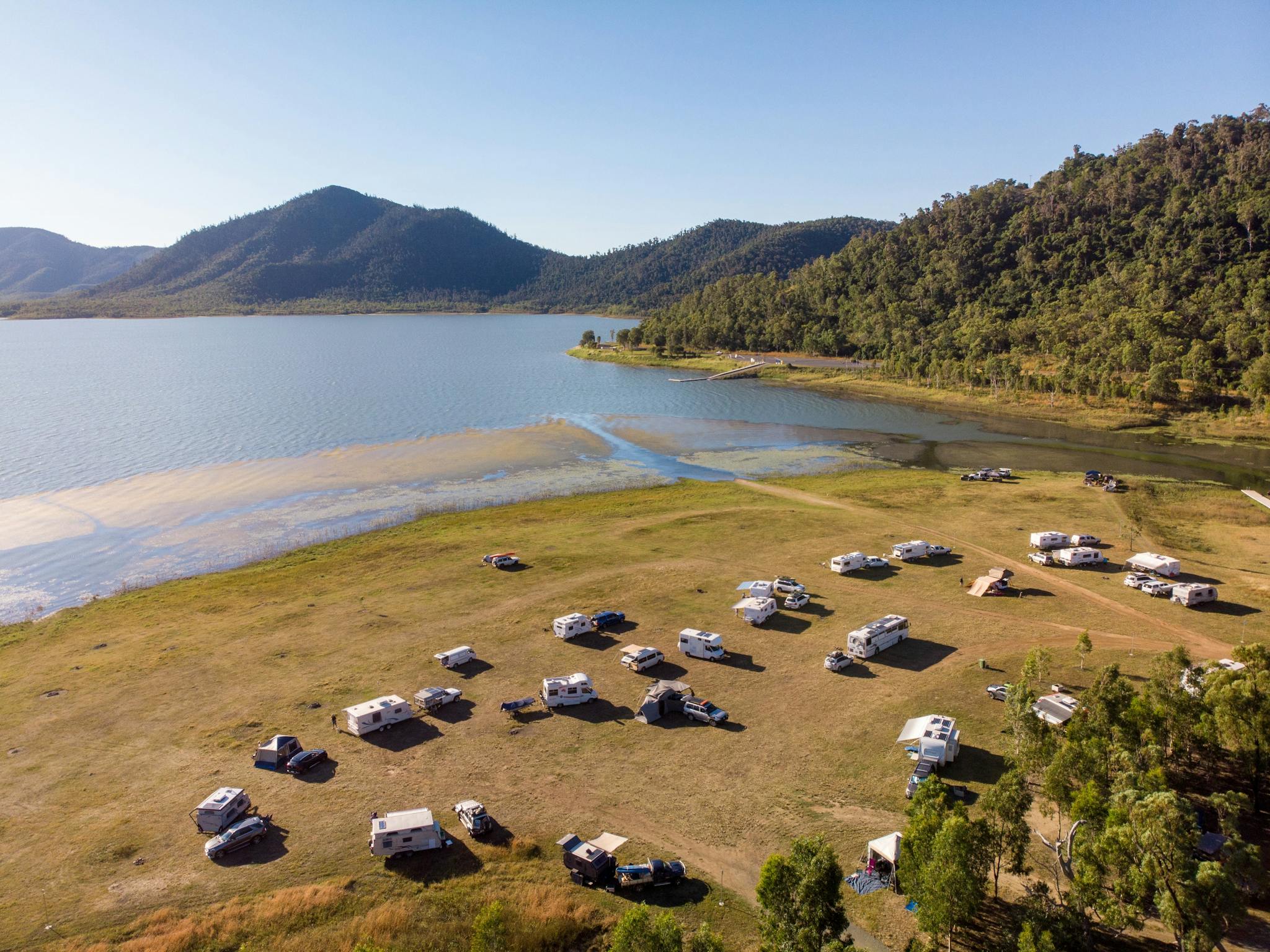 Camper vans parked at the shores of Lake Proserpine with mountains in the background Camper vans parked at the shores of Lake Proserpine with mountains in the background