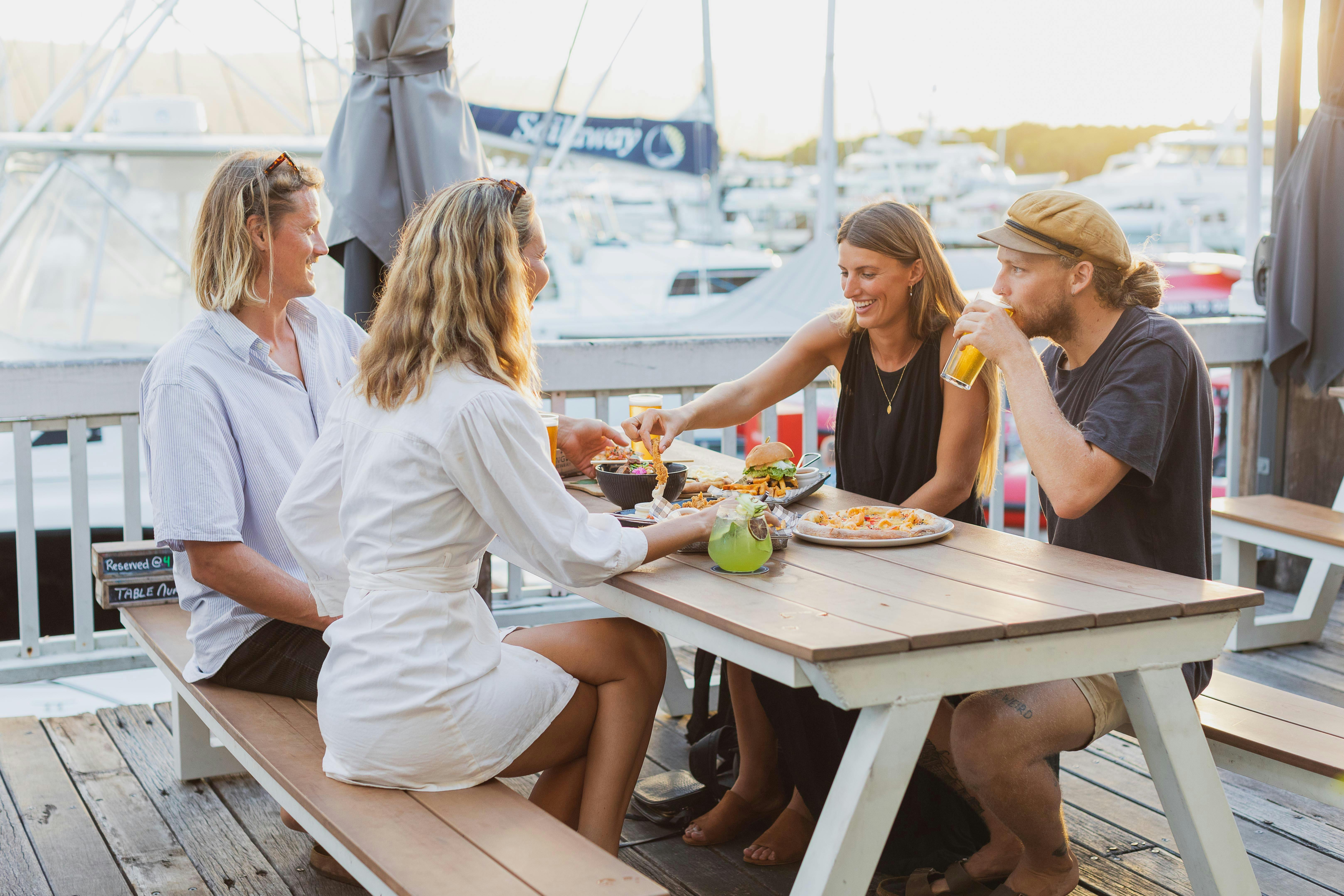 2 couples enjoying Food & drinks on the marina