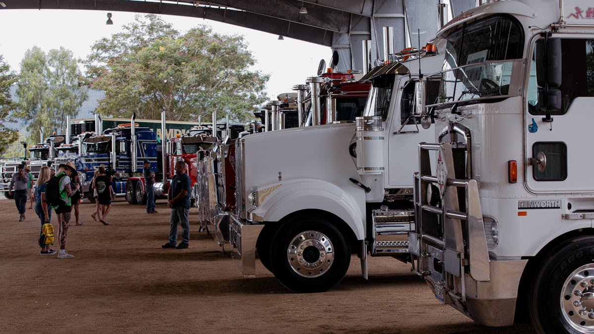Custom trucks lined up on display inside a large shed at Rockynats.