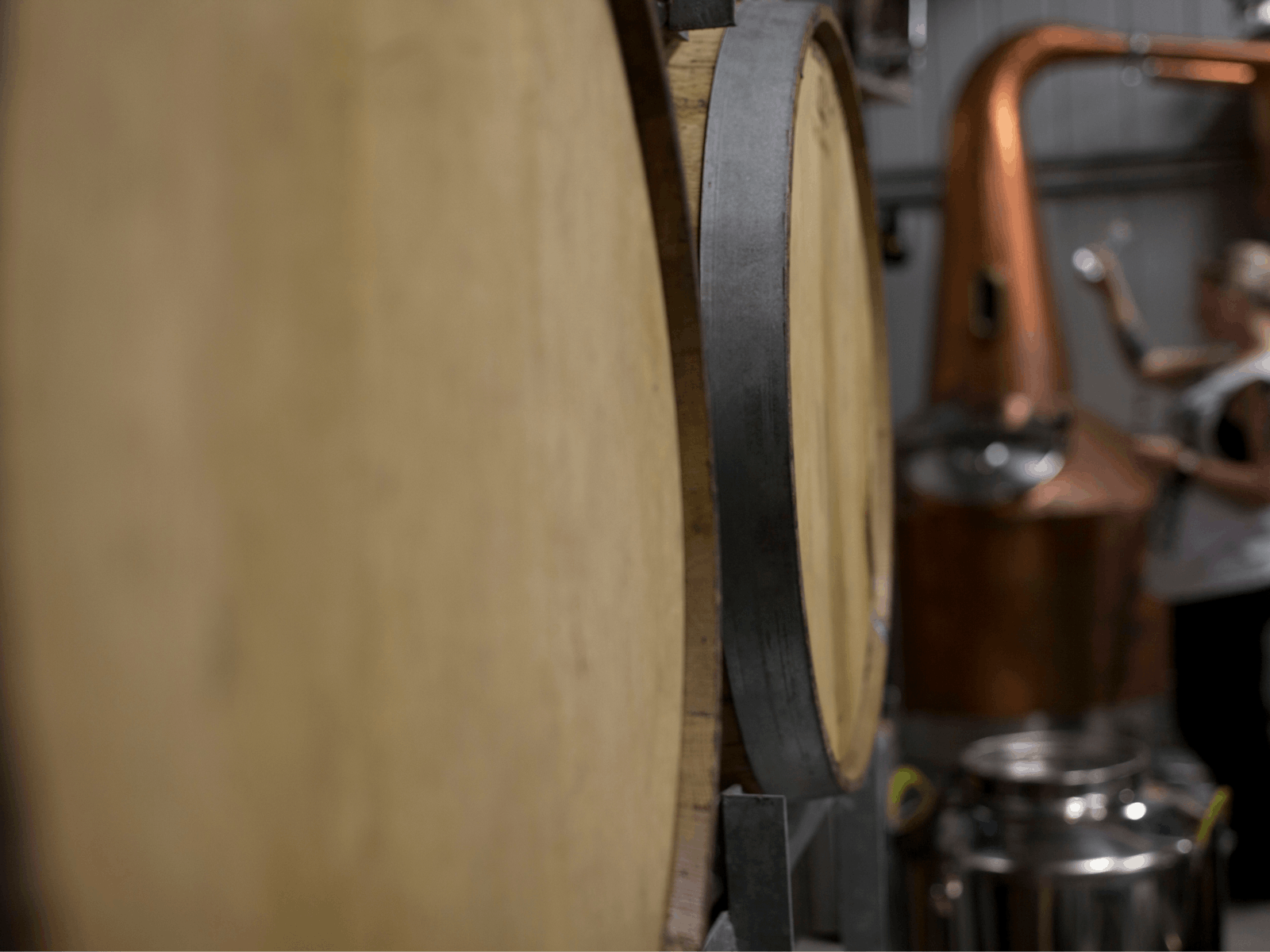 Rum barrels in the foreground with Ally distilling in the background.