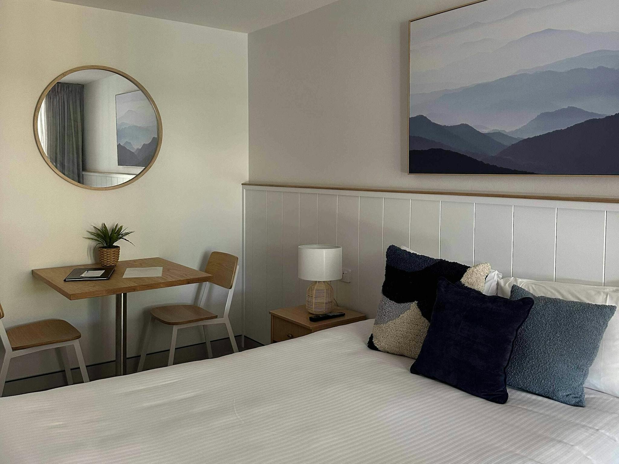 Bed with shite doona and blue cushions and blue mountain image
