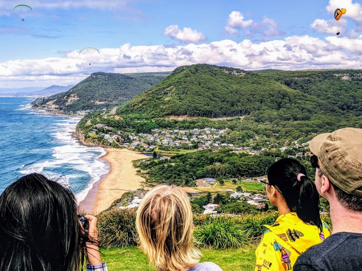travellers looking out at the beautiful view of the pacific ocean and town at bald hill lookout
