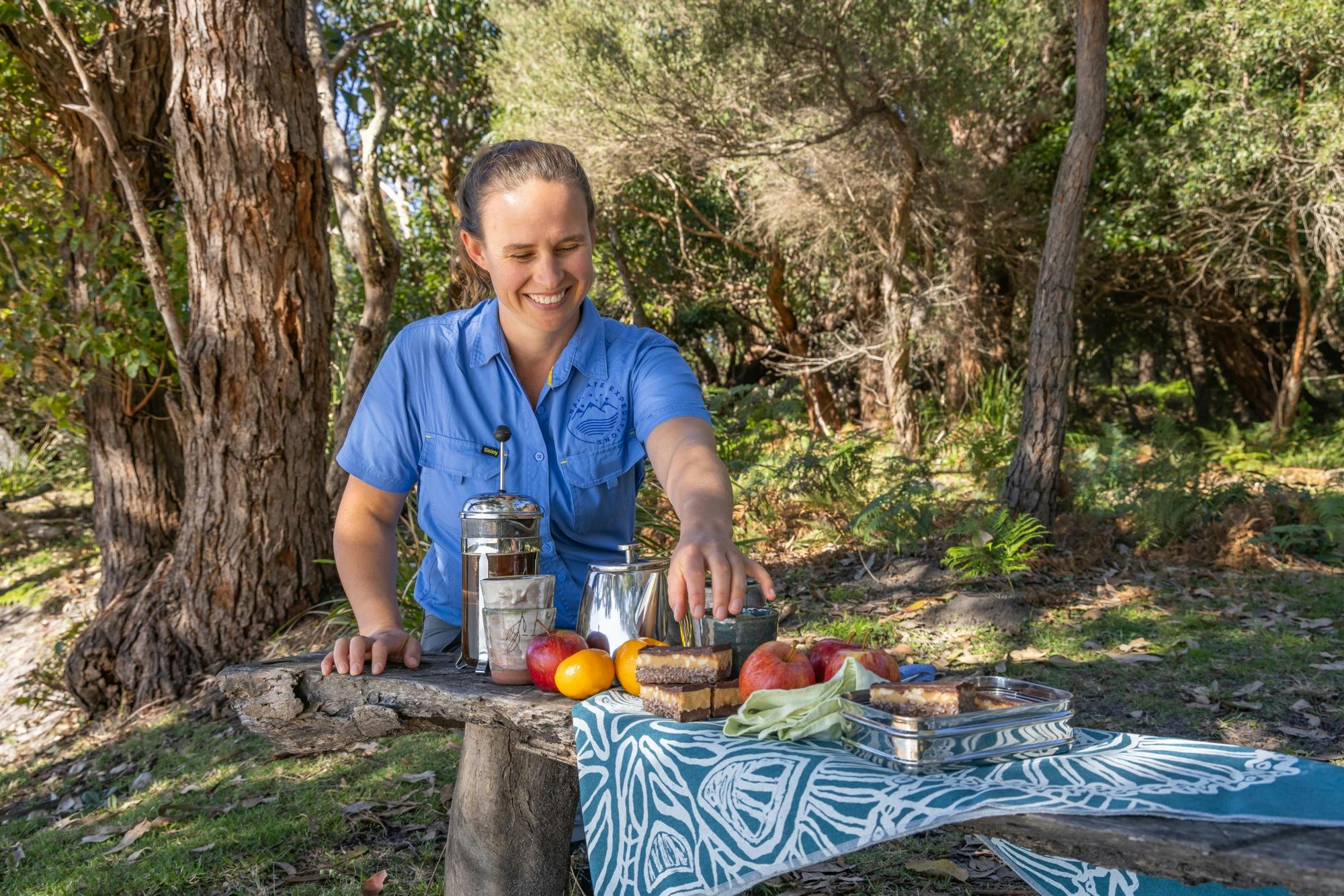 Tour guide setting out morning tea in the bush