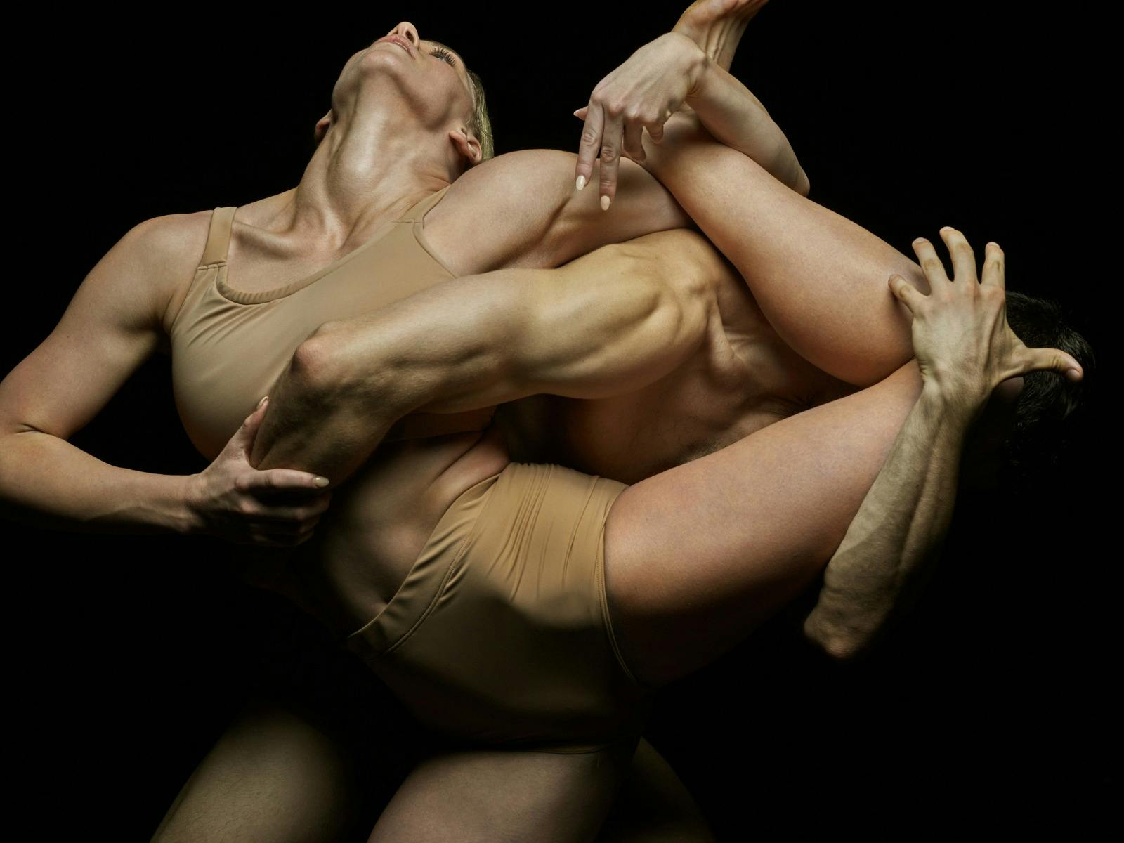 Two dancers are in a contortion pose